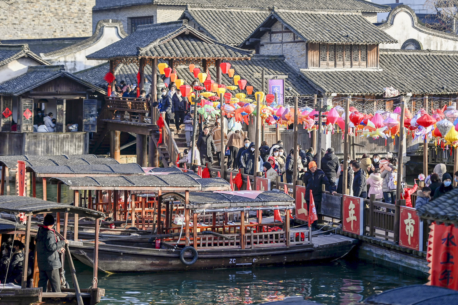 Turisté navštěvují „trh na vodě“ ve scénické oblasti Wuzhen ve městě Tongxiang v provincii Zhejiang v Číně. (Huang Zongzhi/Agentura Nová Čína)