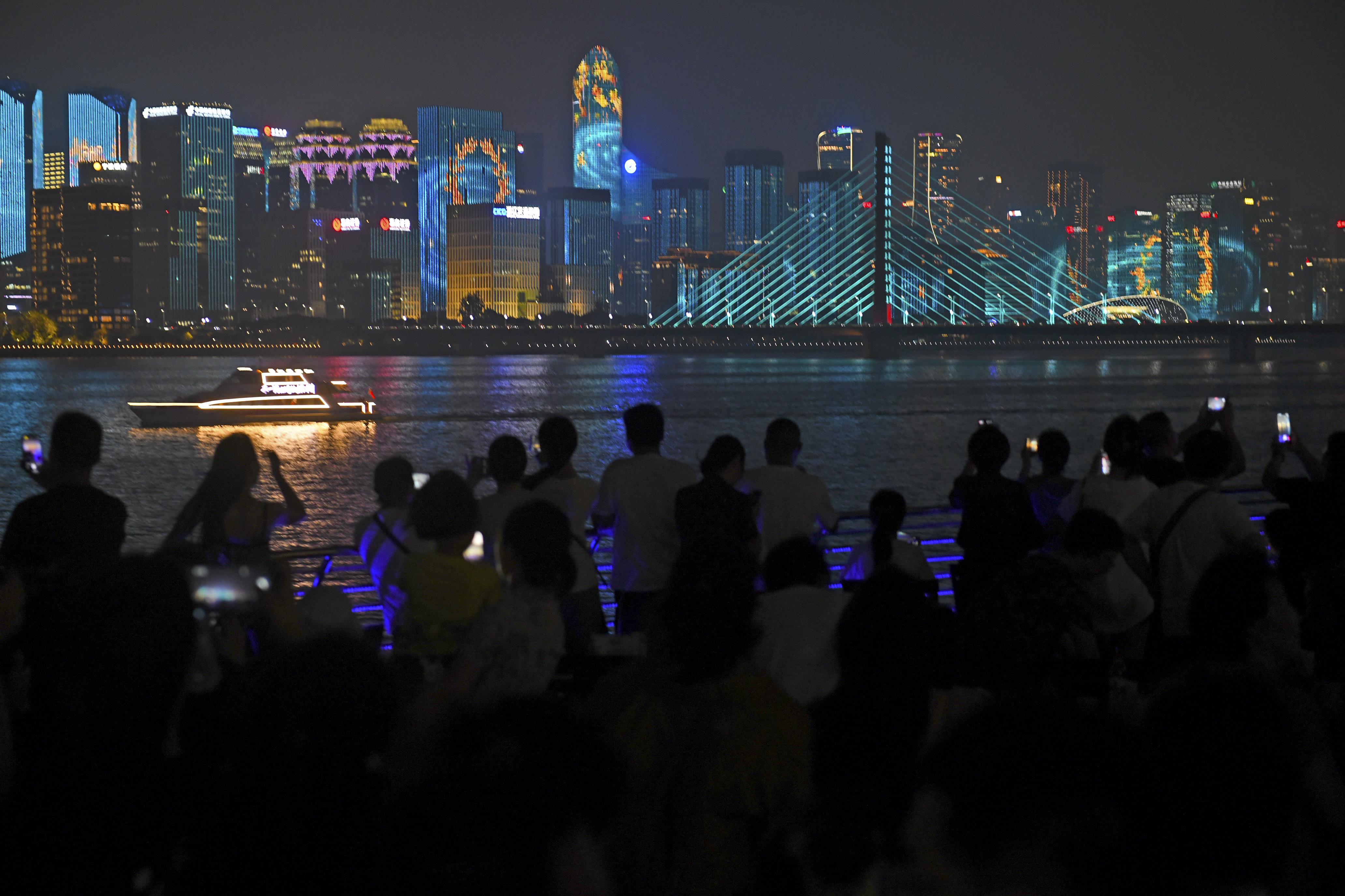 Mnoho místních obyvatelů města Hangzhou a turistů fotí nádherné světelné show na obou stranách řeky Qiantang. (Zdroj: Pan Di/Bright Photos)