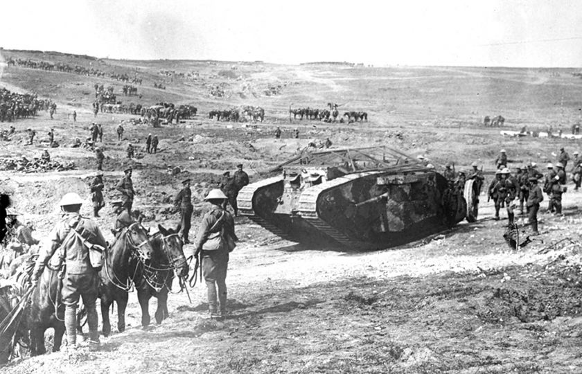 Bitva na Sommě (červenec-listopad 1916). Skupina britských vojáků s koňmi sleduje příjezd tanku Mk 1. Foto: Profimedia