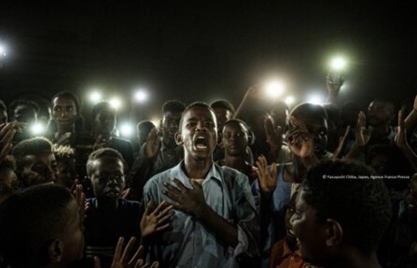 Snímek japonského fotografa Yasuyoshiho Chiby Straight Voice (Jasný hlas) zobrazuje mladého muže, který mezi demonstranty v Sudánu recitoval básně (výřez).