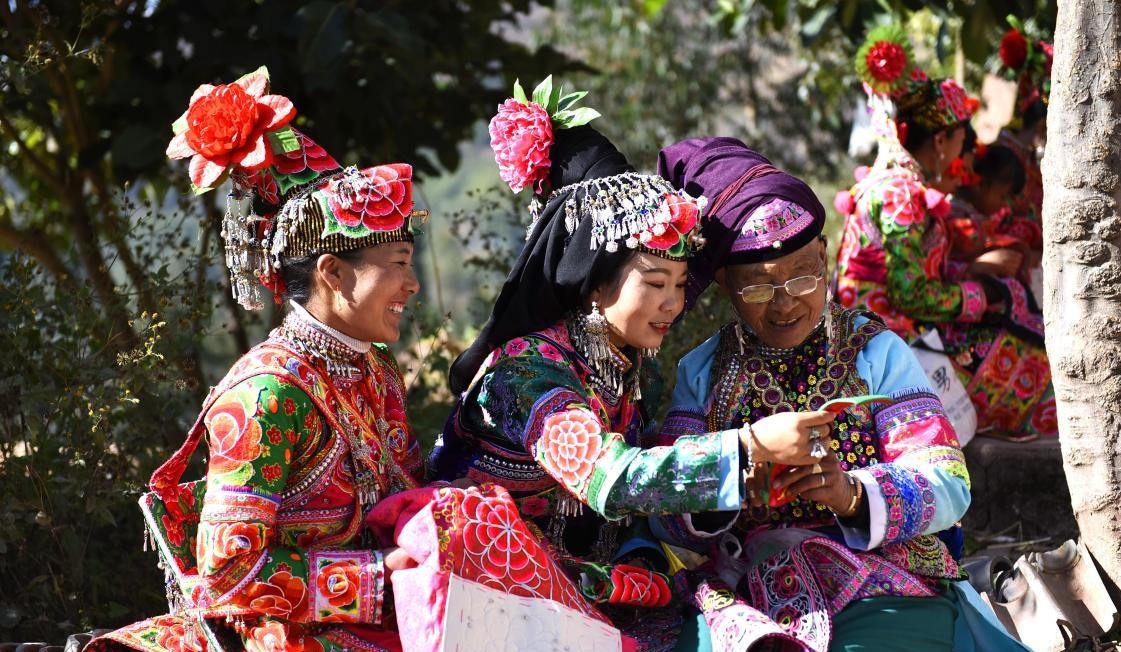 Ženy etnické menšiny Yi ve vesnici Bijiada v městečku Dacang v okresu Weishan v prefektuře Dali v provincii Yunnan šijí tradiční oděvy. Národní řemeslo se stalo novým průmyslovým odvětvím zmírňujícím chudobu. Foto: Zhang Shulu / Guangming Picture. 